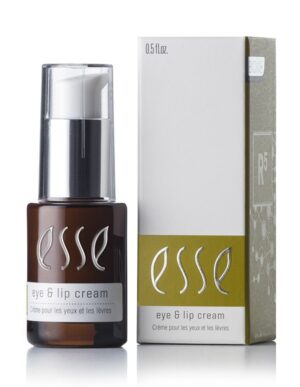 A brown bottle of Esse Eye & Lip Cream with a white pump dispenser is displayed next to its white and green box packaging. The text on the bottle and box reads "Esse Eye & Lip Cream - Crème pour les yeux et les lèvres." The bottle contains 0.5 fl oz of product.