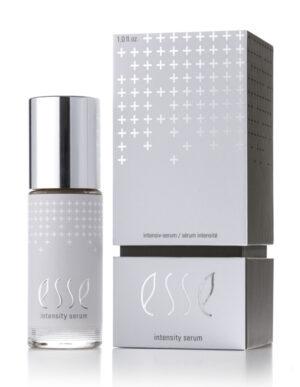 A bottle of Esse Intensity Serum with a shiny silver cap sits beside its matching silver and white box, both displaying minimalist text and a pattern of white plus signs.
