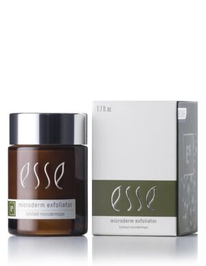 A brown jar of Esse Microderm Exfoliator with a black lid sits beside its packaging. The box is white with grey and green accents, showcasing the same product name and branding. Both the jar and the box have a glossy finish that reflects the light.