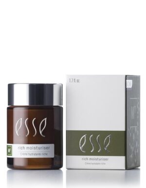 A jar of Esse Rich Moisturiser is displayed beside its packaging. The jar is dark brown, topped with a sleek black lid and adorned with white text. Its accompanying white box showcases the brand logo and product name prominently, highlighted by a green accent stripe near the bottom that includes additional information.