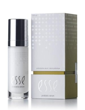 An Esse Probiotic Serum sits beside its corresponding box. The bottle is white with silver accents and a black cap, proudly showcasing the "esse" logo. The similarly white box sports a minimalist design adorned with small cross symbols and the "esse" logo.