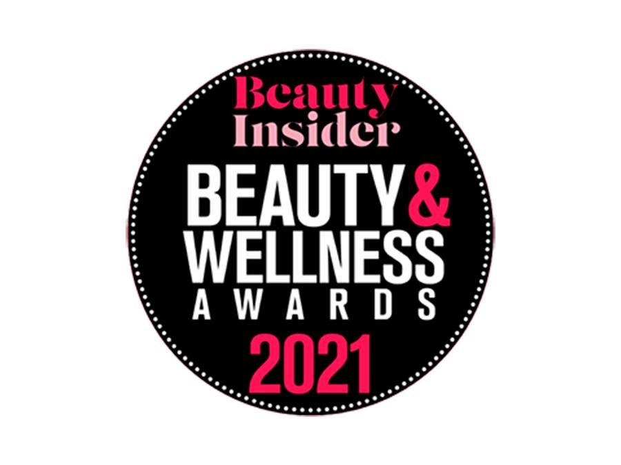 A circular logo with a black background. Inside, it reads "Beauty Insider BEAUTY & WELLNESS AWARDS 2021" in white and pink text. The border of the circle is dotted with small white dots.