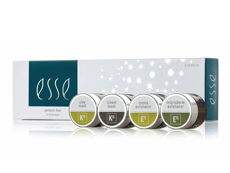 A box of Esse skincare products with four small jars displayed in front. The jars are labeled as clay mask (K5), cream mask (K6), cocoa exfoliator (E5), and microderm exfoliator (E6). The packaging is white with green and black accents.