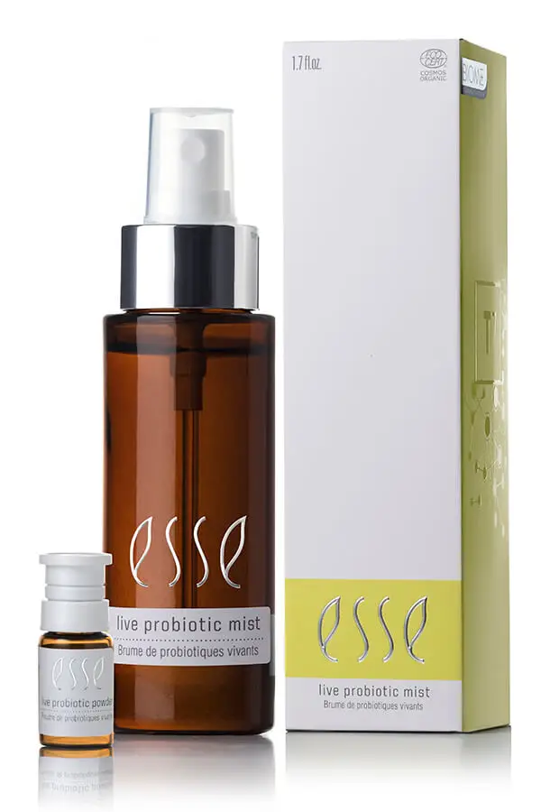 A brown spray bottle labeled "Live Probiotic Mist" stands beside a small vial and a white-and-yellow box, all featuring the Esse logo and matching product details.