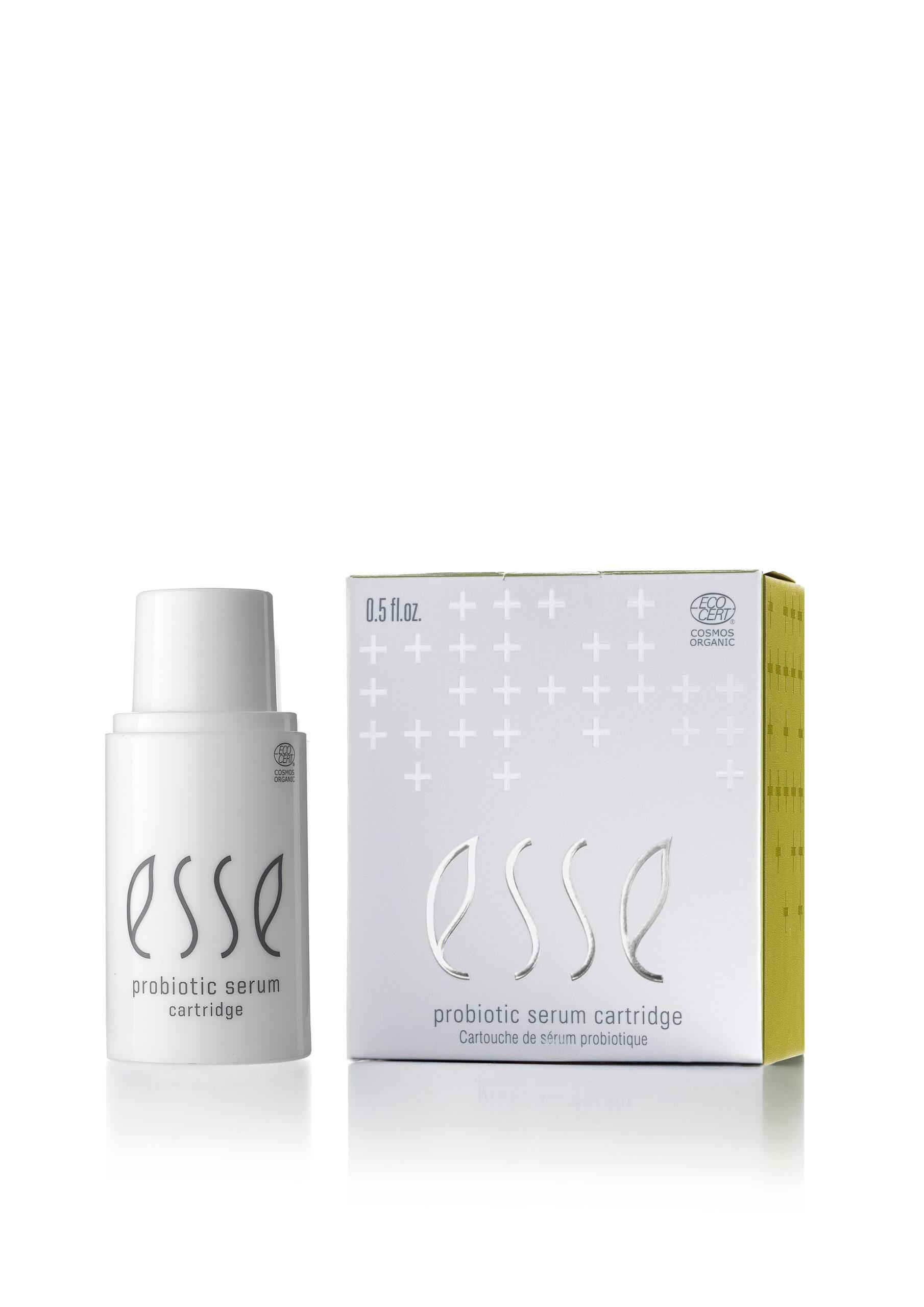 A white bottle labeled "Esse Probiotic Serum" stands beside its matching box, which is white with gray and yellow accents and features similar branding.