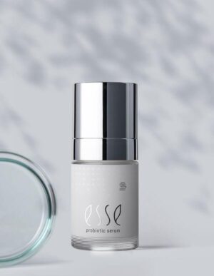 A silver and white bottle labeled "Import placeholder for 56489" stands upright on a light surface, with a partially visible glass jar lid to the left and a softly blurred background.